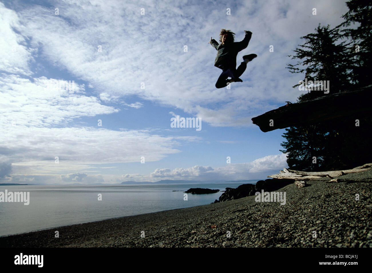 Ragazzo salta fuori registro Isl Zarembo sudest AK estate scenic Foto Stock