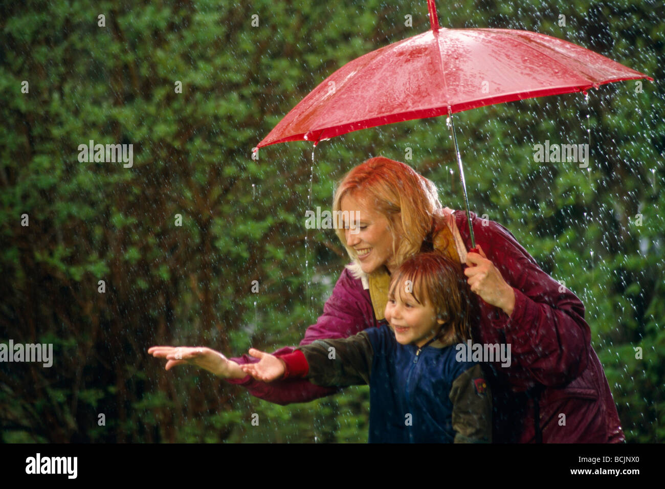 Little Boy & Mom w/ Ombrello pioggia centromeridionale molla AK Foto Stock