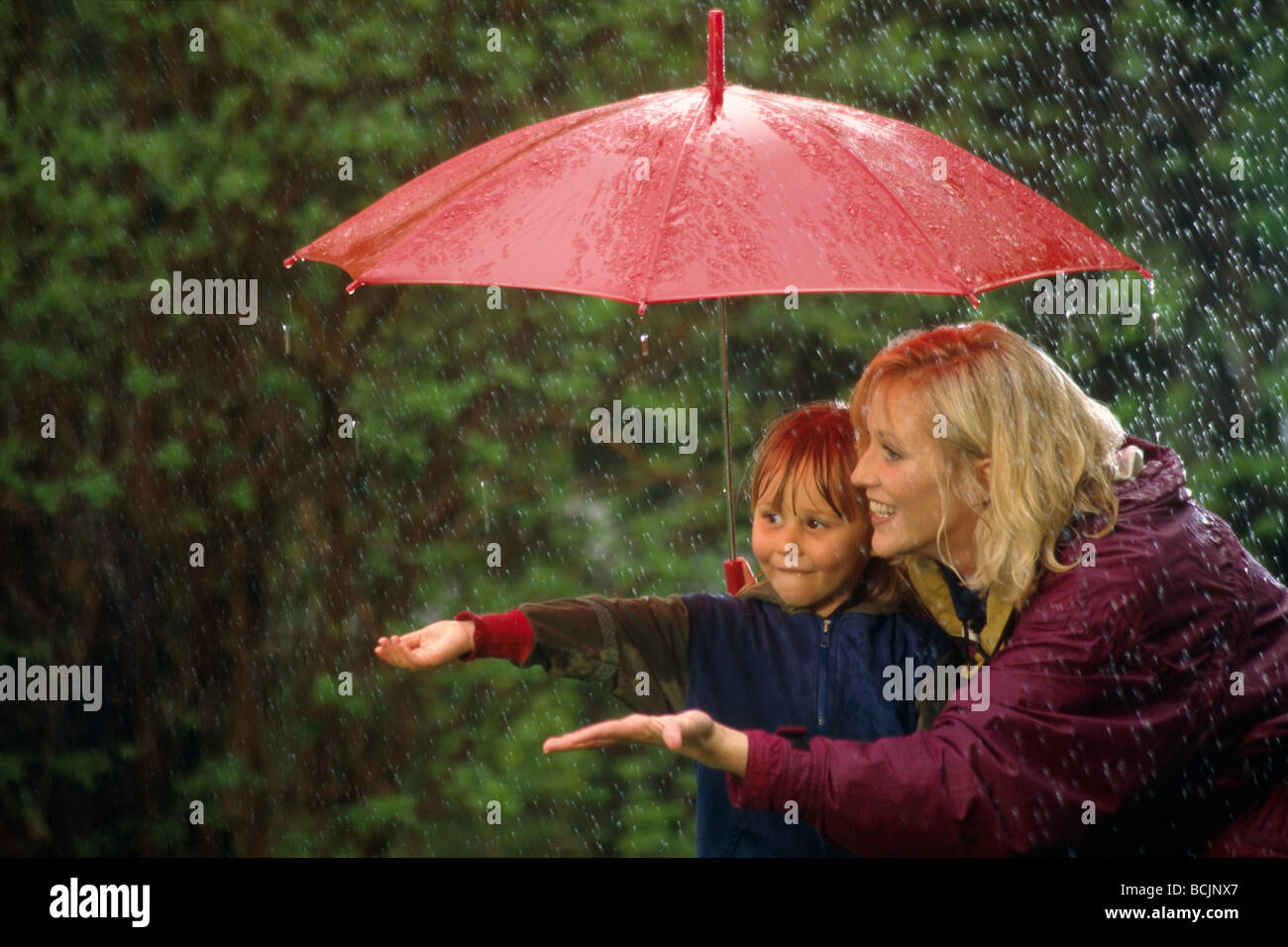 Little Boy & Mom w/ Ombrello pioggia centromeridionale molla AK Foto Stock