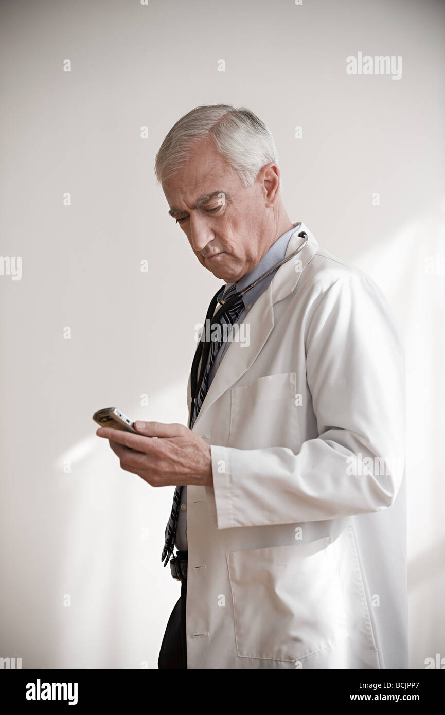 Medico con il cellulare Foto Stock