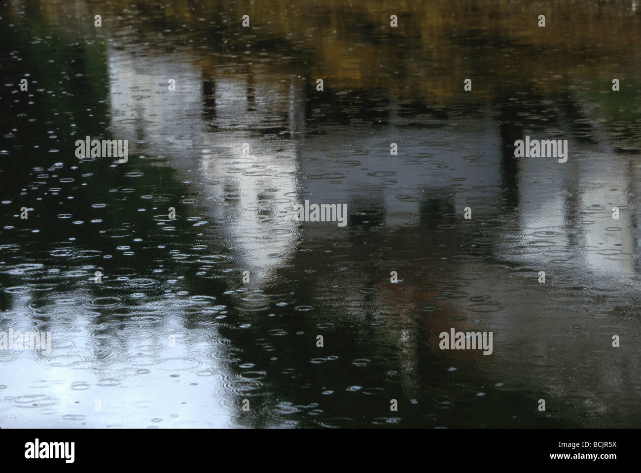 Le gocce di pioggia sul lago di riflessione di clapboard house Alaska Foto Stock