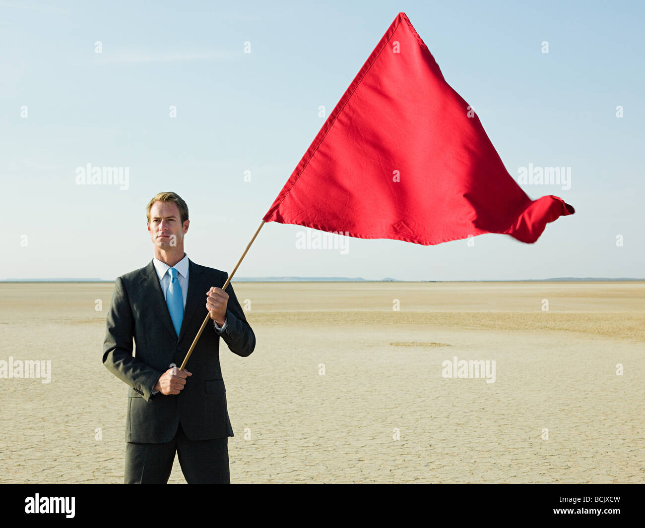 Imprenditore tenendo una bandiera rossa Foto Stock