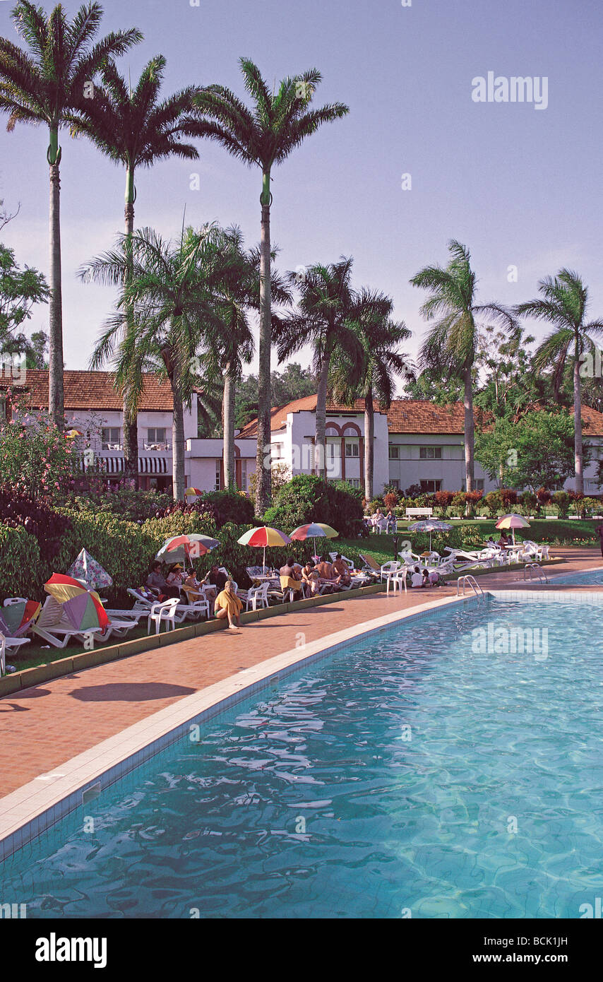 Piscina e palme Lake Victoria Hotel Entebbe in Uganda Africa Orientale turisti prendere il sole sotto gli ombrelloni Foto Stock