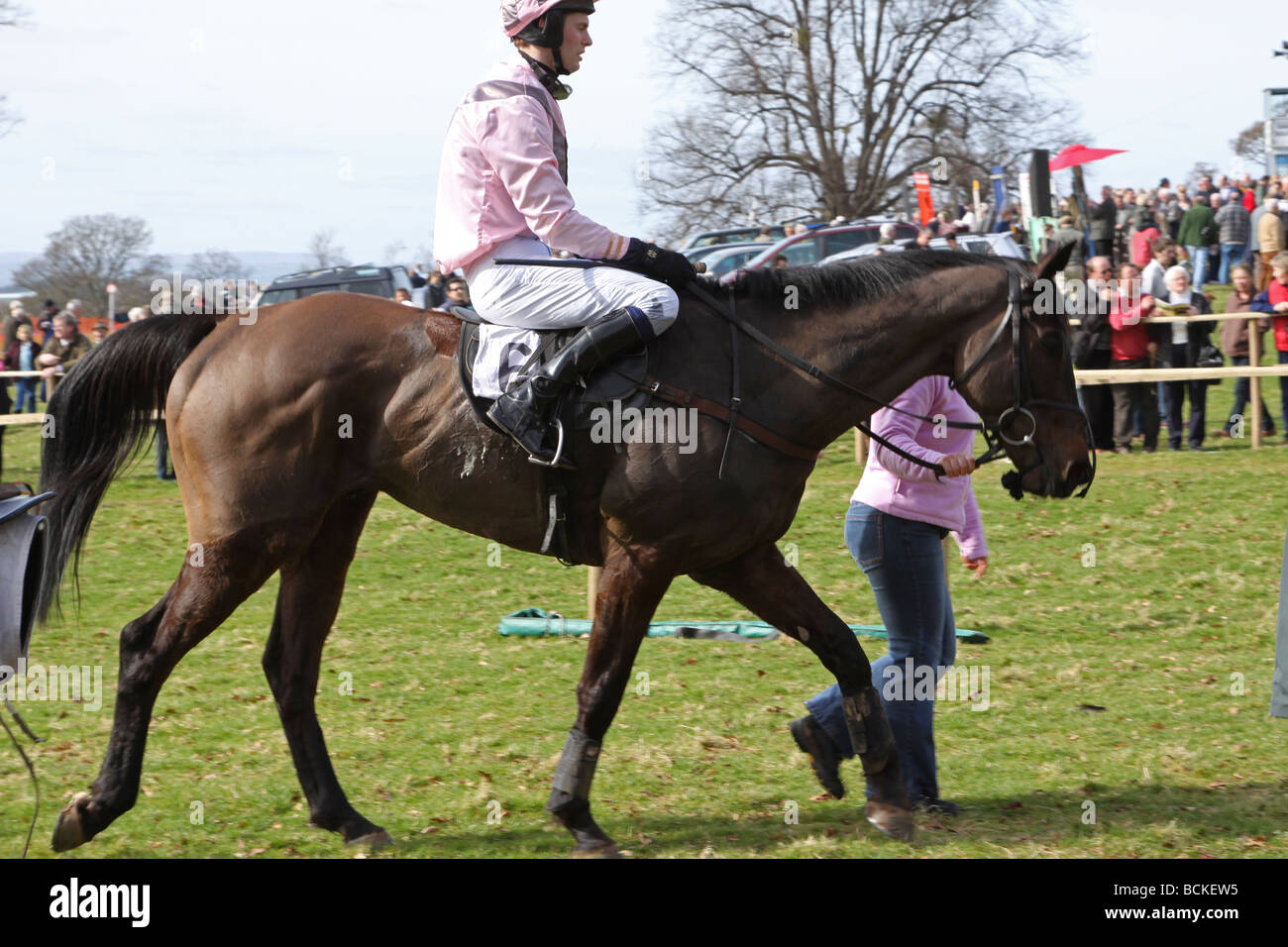 Delle corse ippiche tornare indietro a piedi per il paddock al termine di una gara Foto Stock