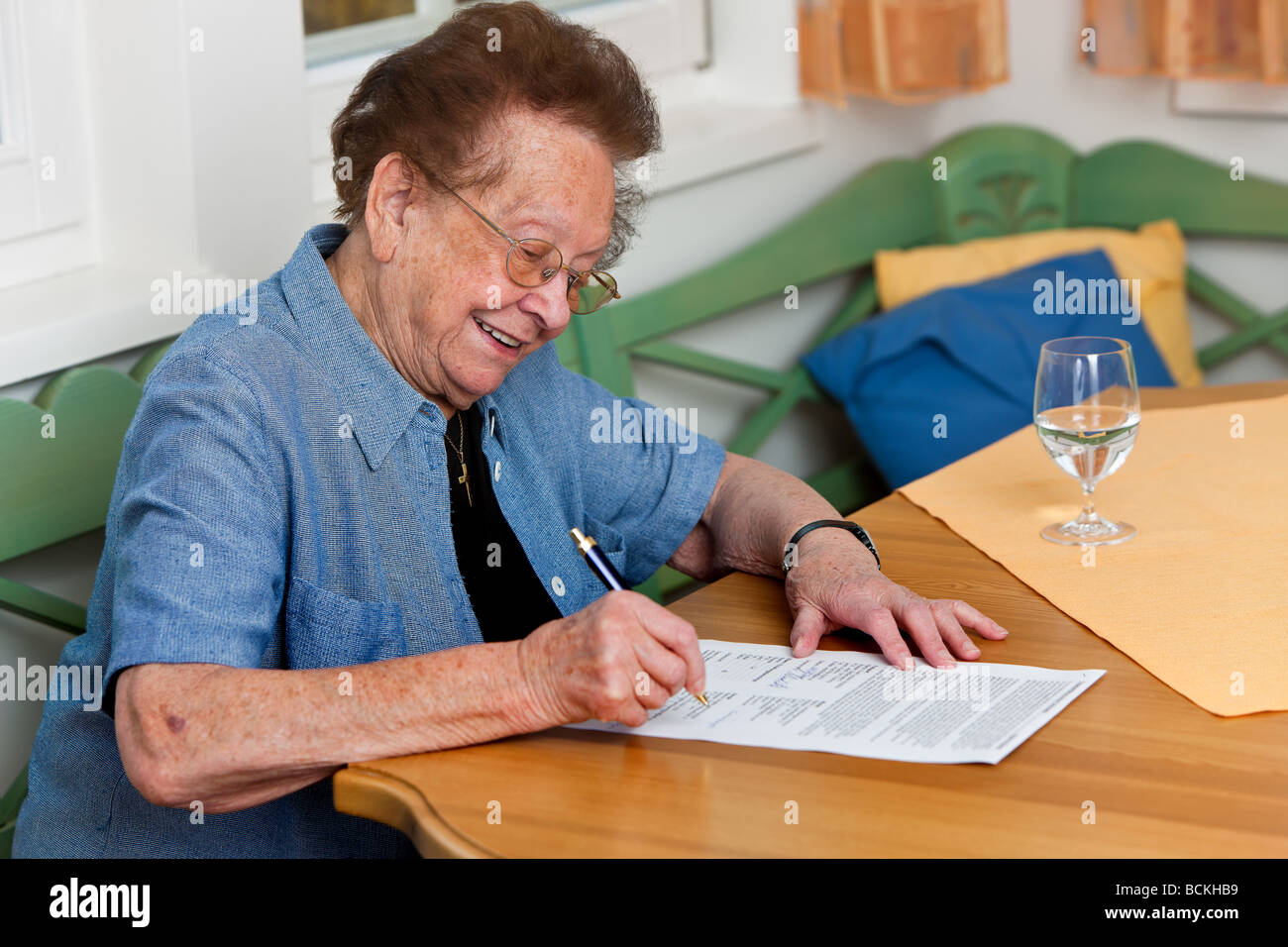 Una vecchia donna a firmare un contratto Foto Stock