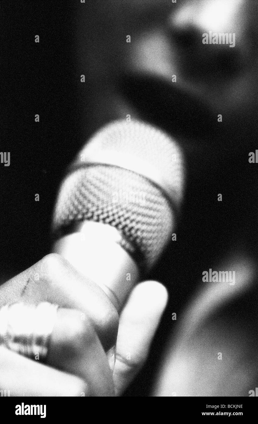 Donna cantare nel microfono, vista parziale, b&W Foto Stock