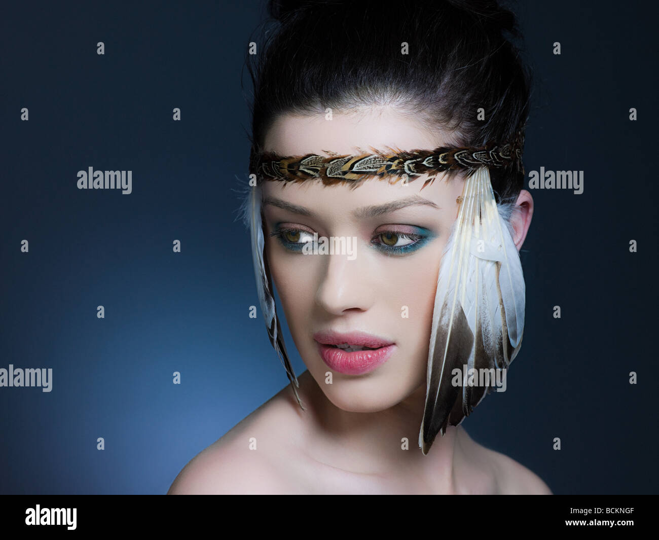 Giovane donna con copricapo di piume Foto Stock