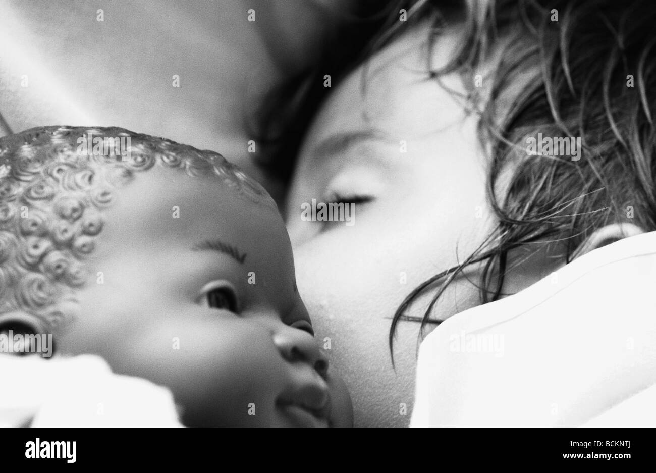 Bambino che dorme con bambola, close-up, b&W Foto Stock