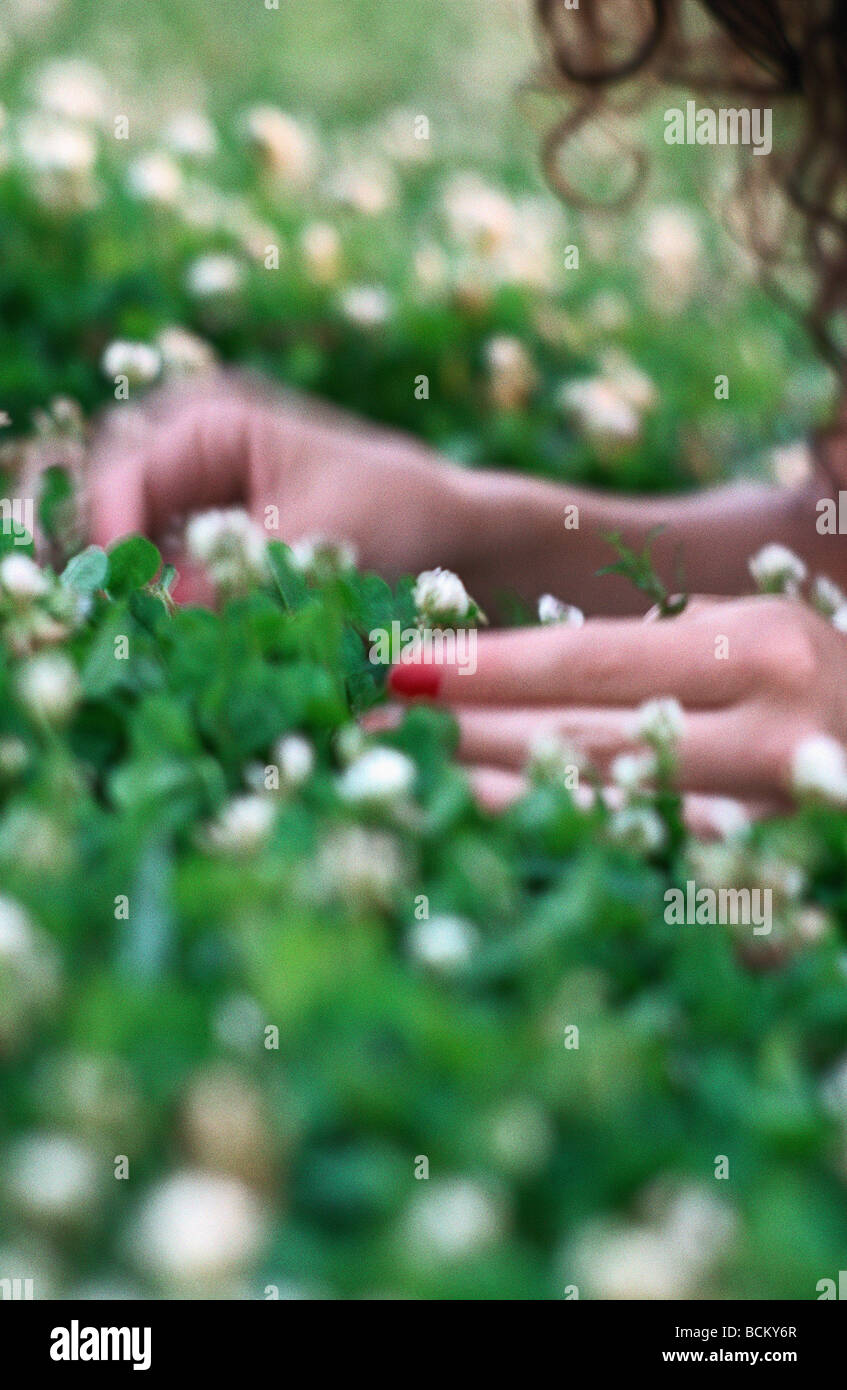 Donna sdraiata in erba, close-up delle mani Foto Stock