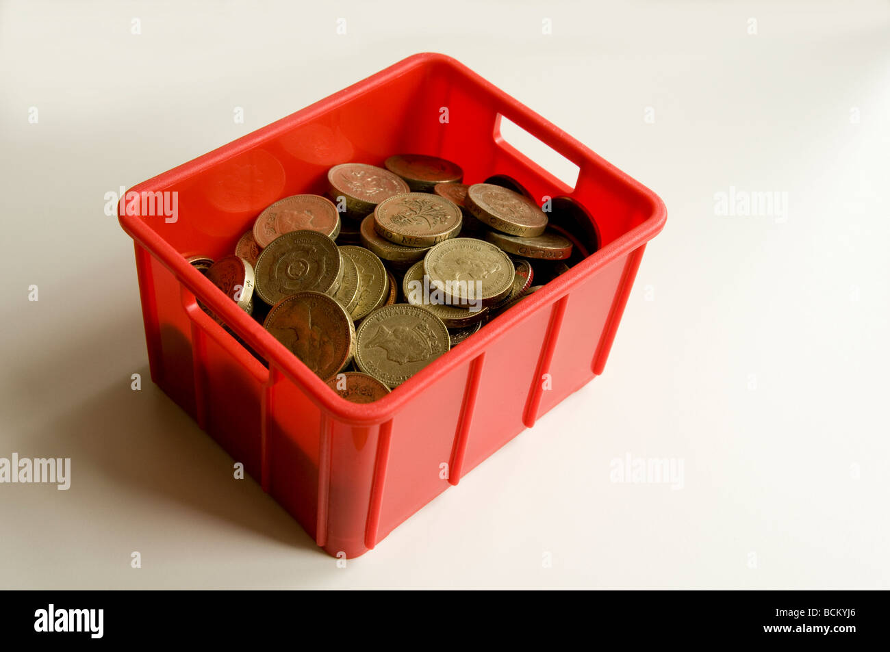 Piccola cassa riempita con monete del Regno Unito - principalmente £1s. In rappresentanza di movimento / spese di trasloco. Foto Stock