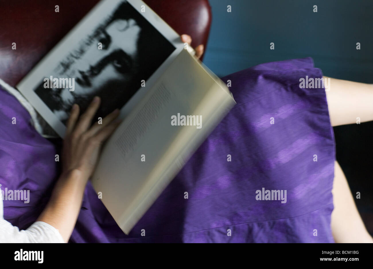 La donna a vestire la lettura di libro di poesie, vista ritagliata della sezione centrale, ad alto angolo di visione Foto Stock