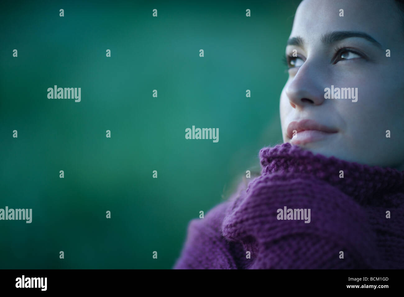 Donna maglione di trazione fino alla faccia, guardando lontano, close-up, ritagliato Foto Stock