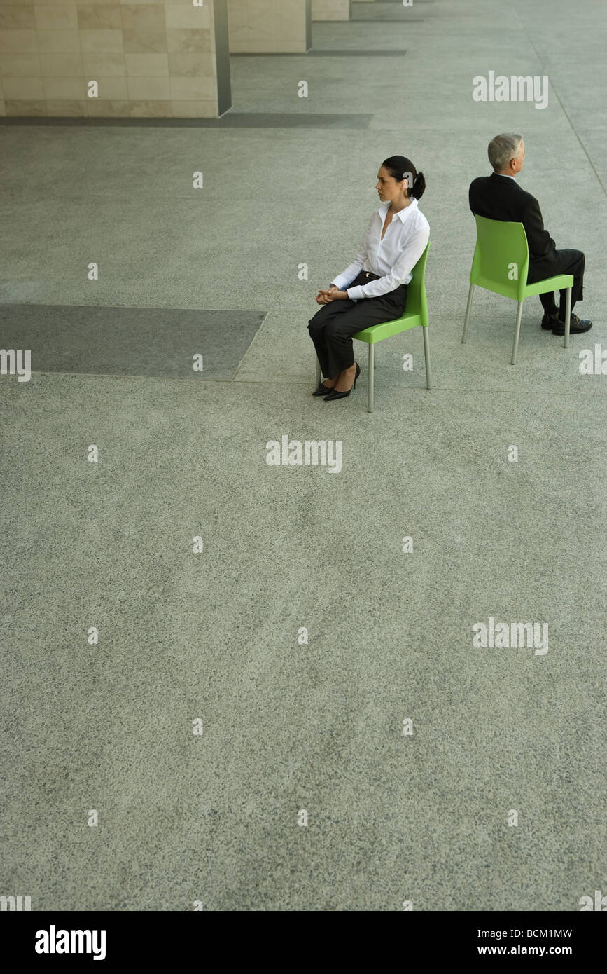 Imprenditrice e imprenditore seduta di schiena, ad alto angolo di visione a piena lunghezza Foto Stock