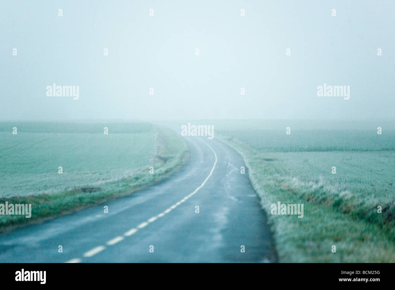 La curvatura della strada nel paesaggio di nebbia Foto Stock