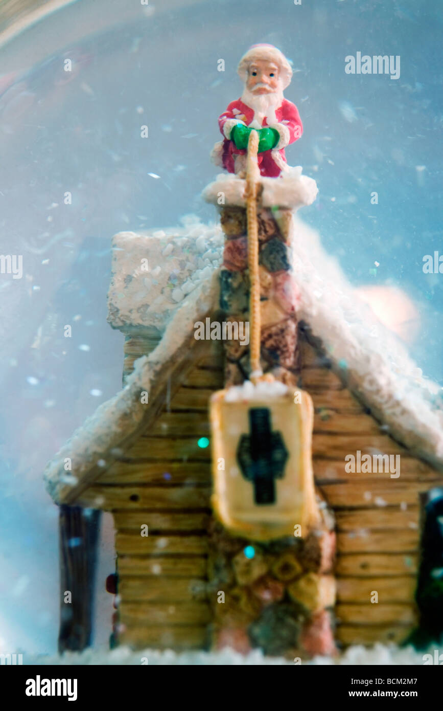 Snow Globe con Babbo Natale figurina sul camino, close-up Foto Stock