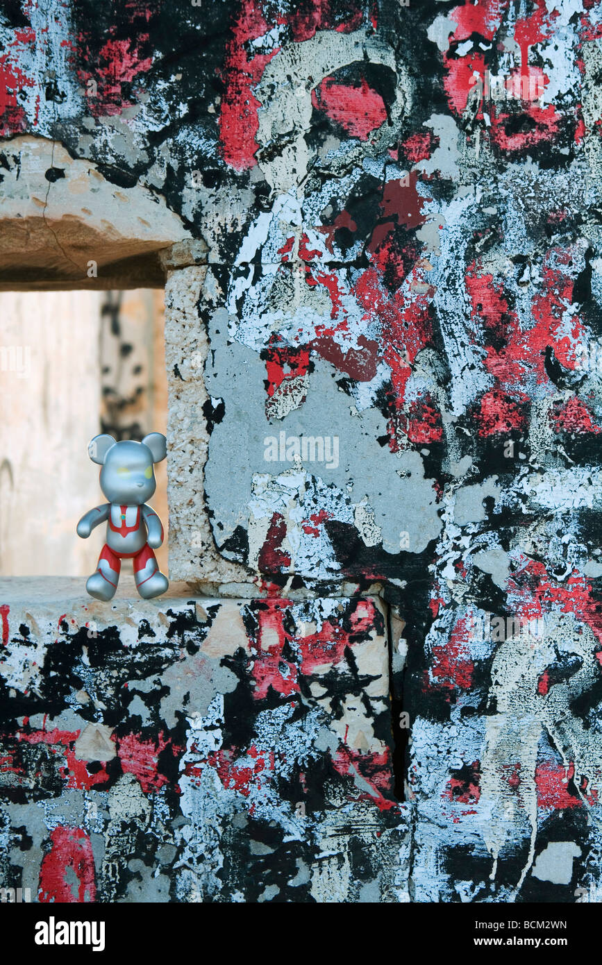 Orso in plastica figurina in piedi nel foro nella parete graffitied Foto Stock