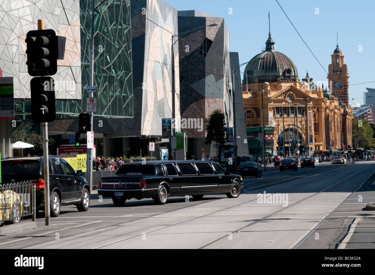 Stretch Limousine su Flinders Street con Federation Square complesso e la stazione di Flinders Street Melbourne Victoria Australia Foto Stock