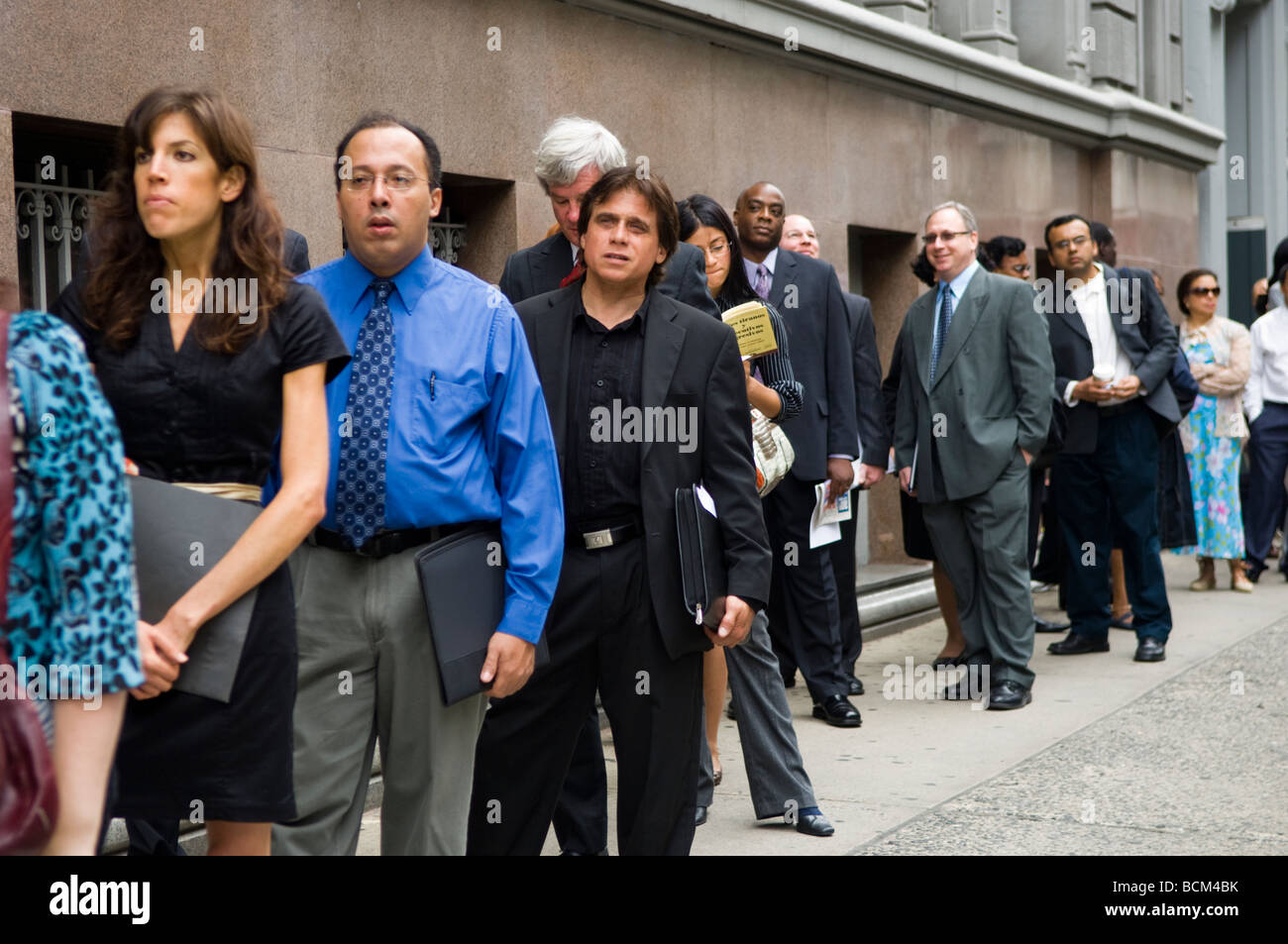 Le persone in cerca di lavoro la linea in attesa per le porte da aprire a una fiera del lavoro in New York Foto Stock