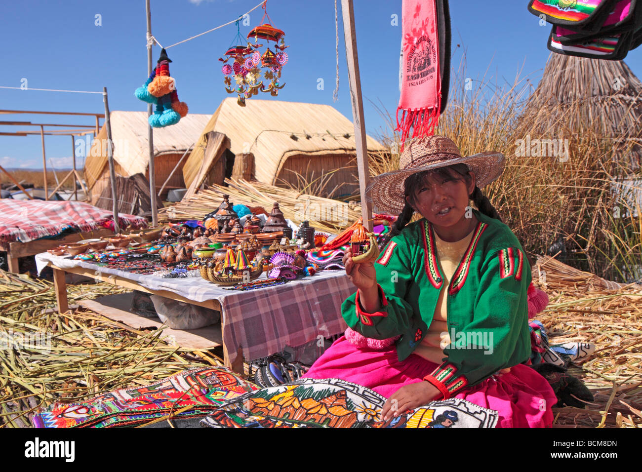 Giovane donna che vende souvenir su un Uro Island, il lago Titicaca, Puno, Perù Foto Stock