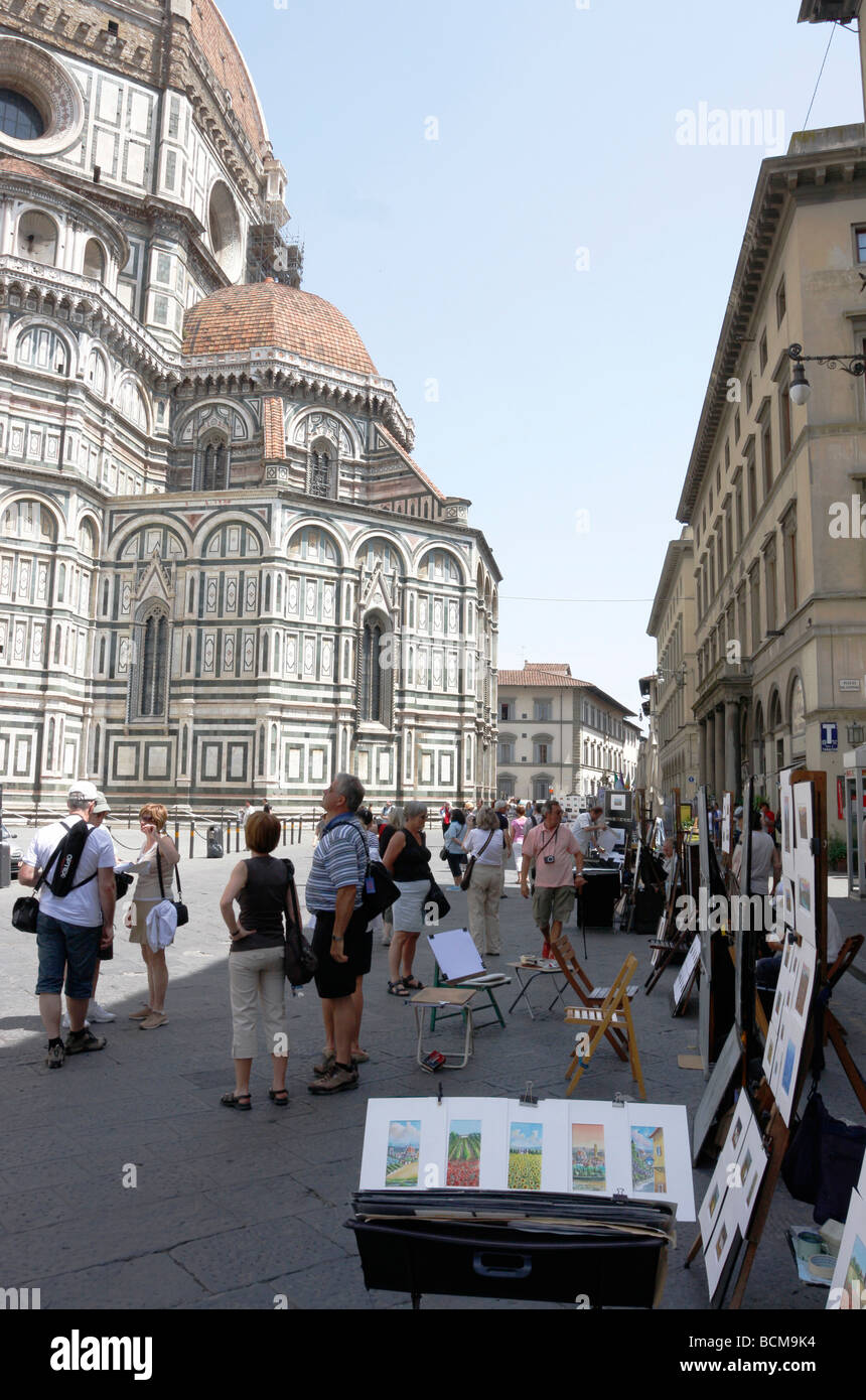 Artisti presentano il loro lavoro per i turisti al di fuori del Duomo e la Torre del Campanile di Firenze, Italia Foto Stock