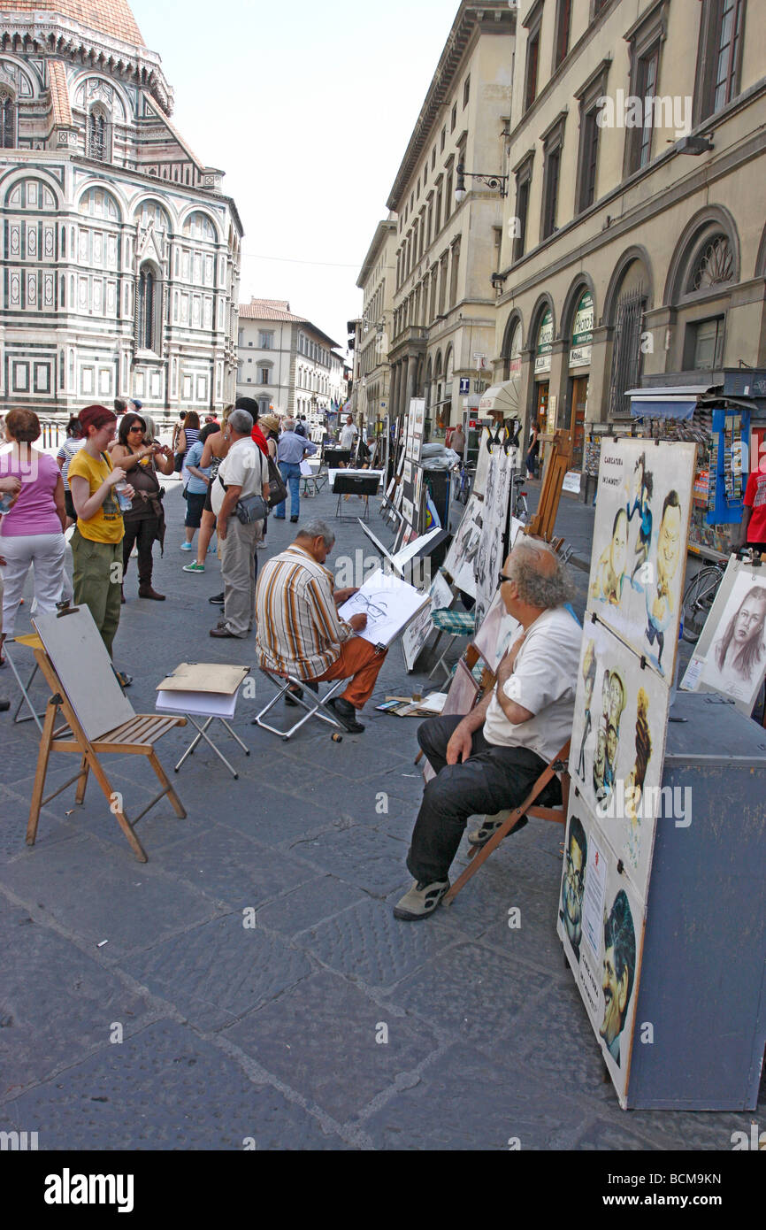 Artisti presentano il loro lavoro per i turisti al di fuori del Duomo e la Torre del Campanile di Firenze, Italia Foto Stock