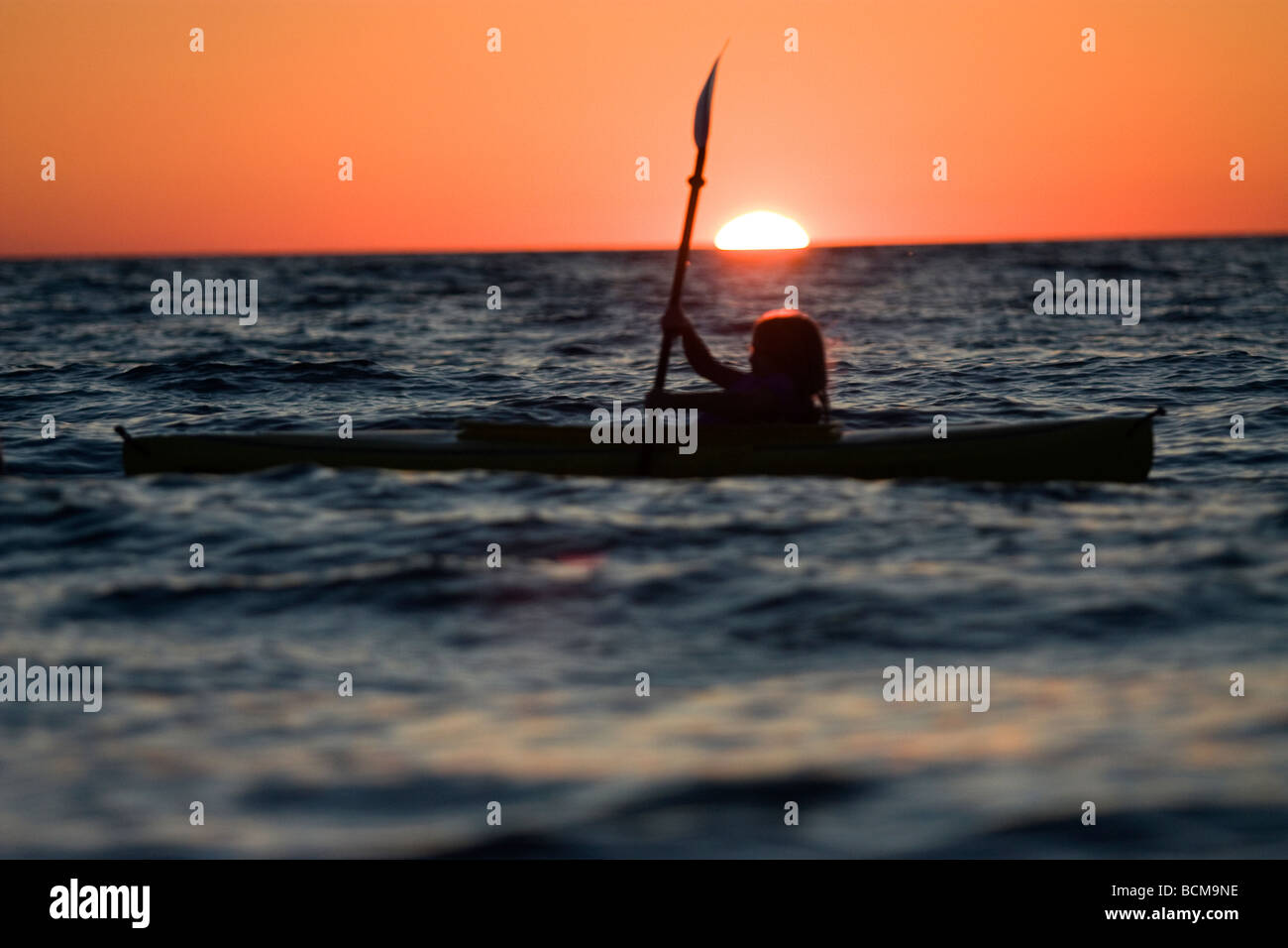 Ragazza giovane kayak al tramonto Foto Stock