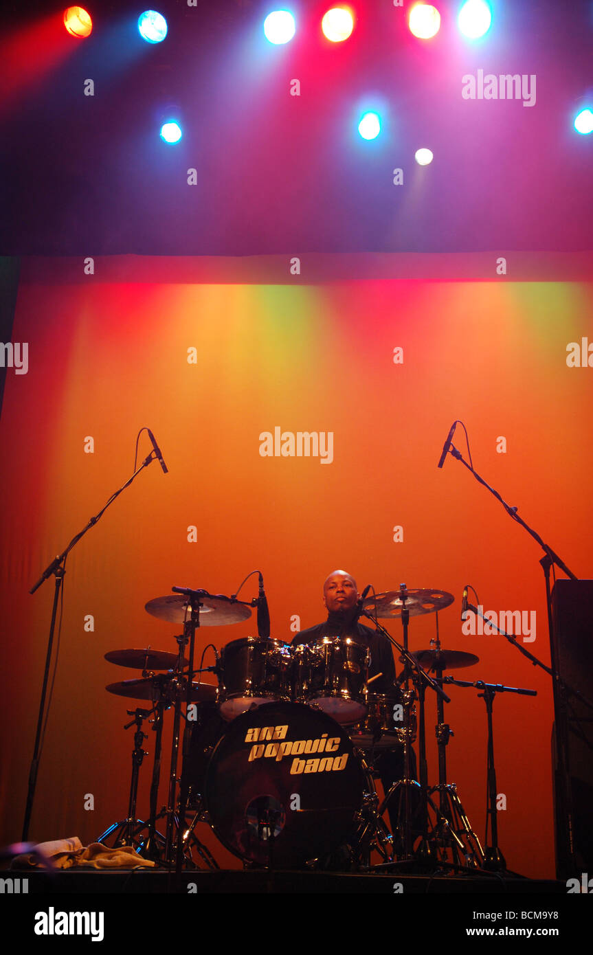 Il batterista sul palco sotto colorata illuminazione scenica Foto Stock