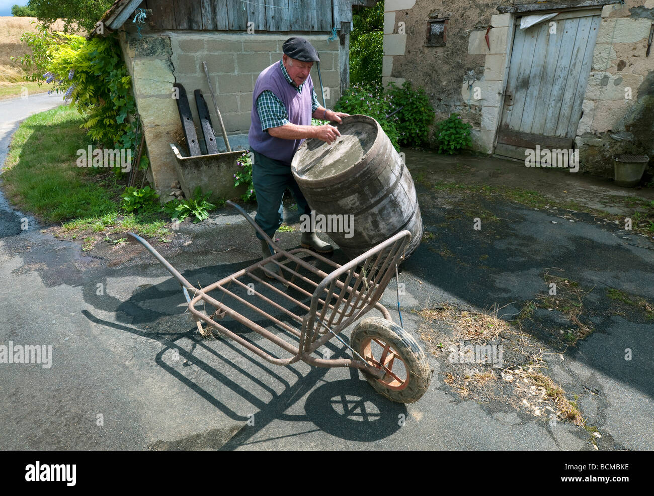 Agricoltore il caricamento di botte di vino sul camion - sud-Touraine, Francia. Foto Stock