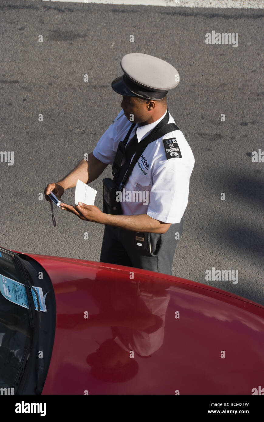 Un assistente di parcheggio la scrittura di un ticket Foto Stock