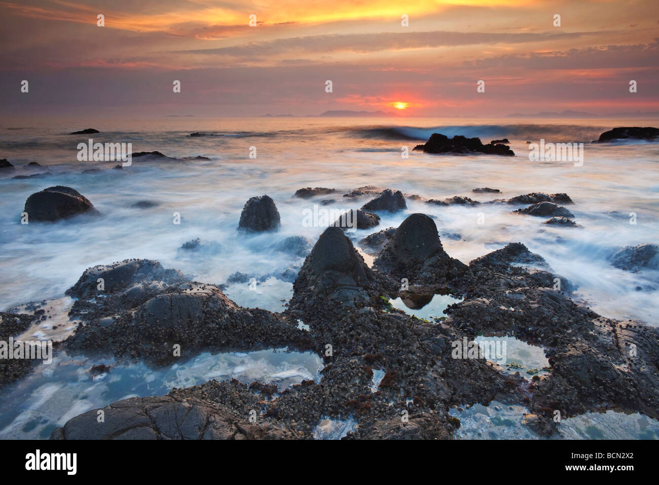 Mare di acqua di lavaggio su rocce nere False Bay Foto Stock