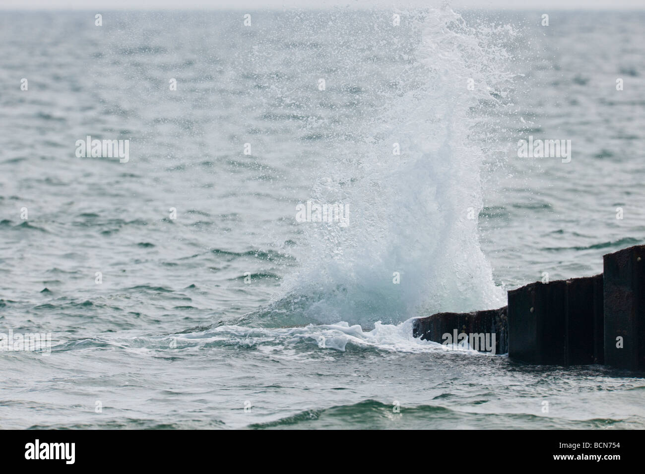 Onde che si infrangono sul mare difese a West Bay nel Dorset Foto Stock