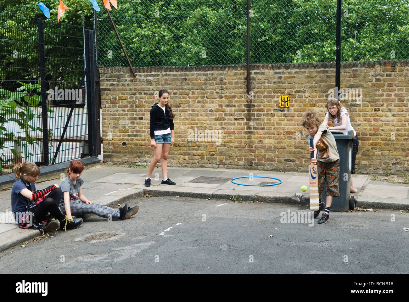 Bambini che giocano a cricket nel ragazzo di strada e ragazze. Brunswick Street Walthamstow London E17 usando la pattumiera al wicket. 2009 2000 HOMER SYKES Foto Stock