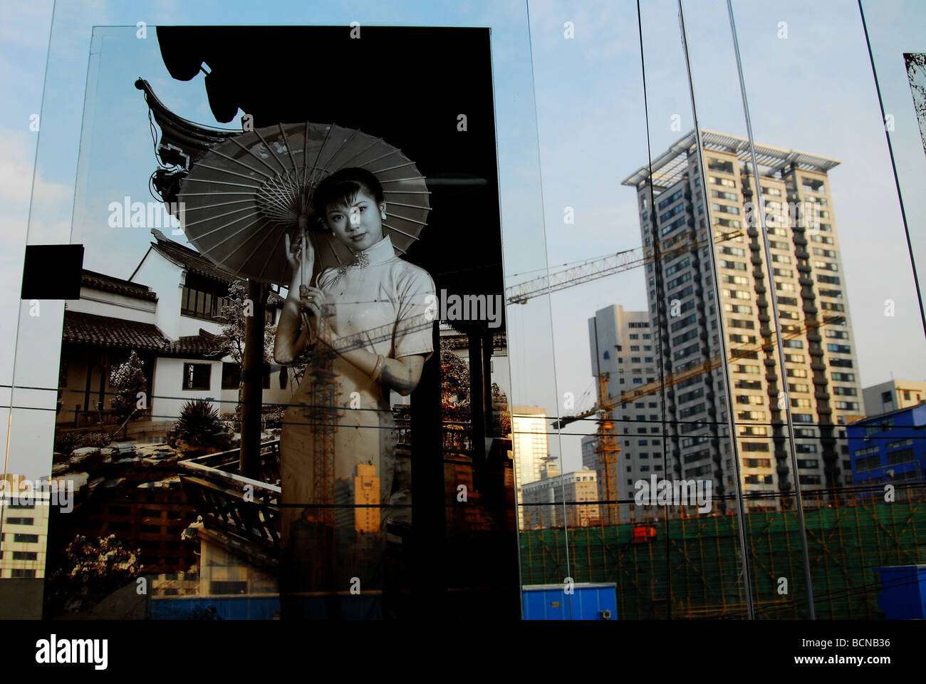 Fotografia in bianco e nero della giovane donna nel tradizionale Qipao contro le moderne highrises, Shanghai, Cina Foto Stock