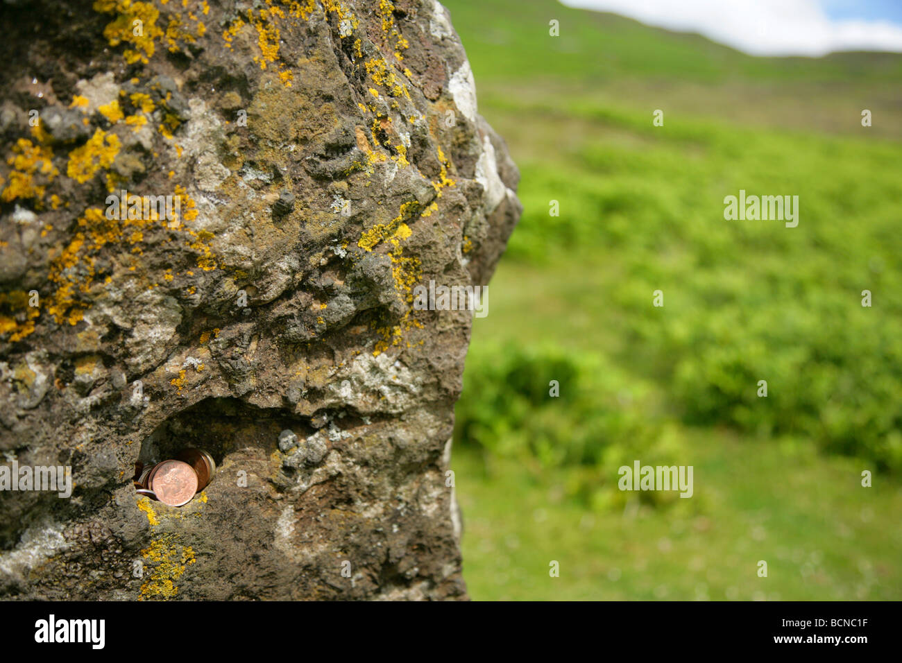 Lucky monete poste in crack in antica pietra permanente presso il villaggio abbandonato di Boreraig, Isola di Skye. Foto Stock