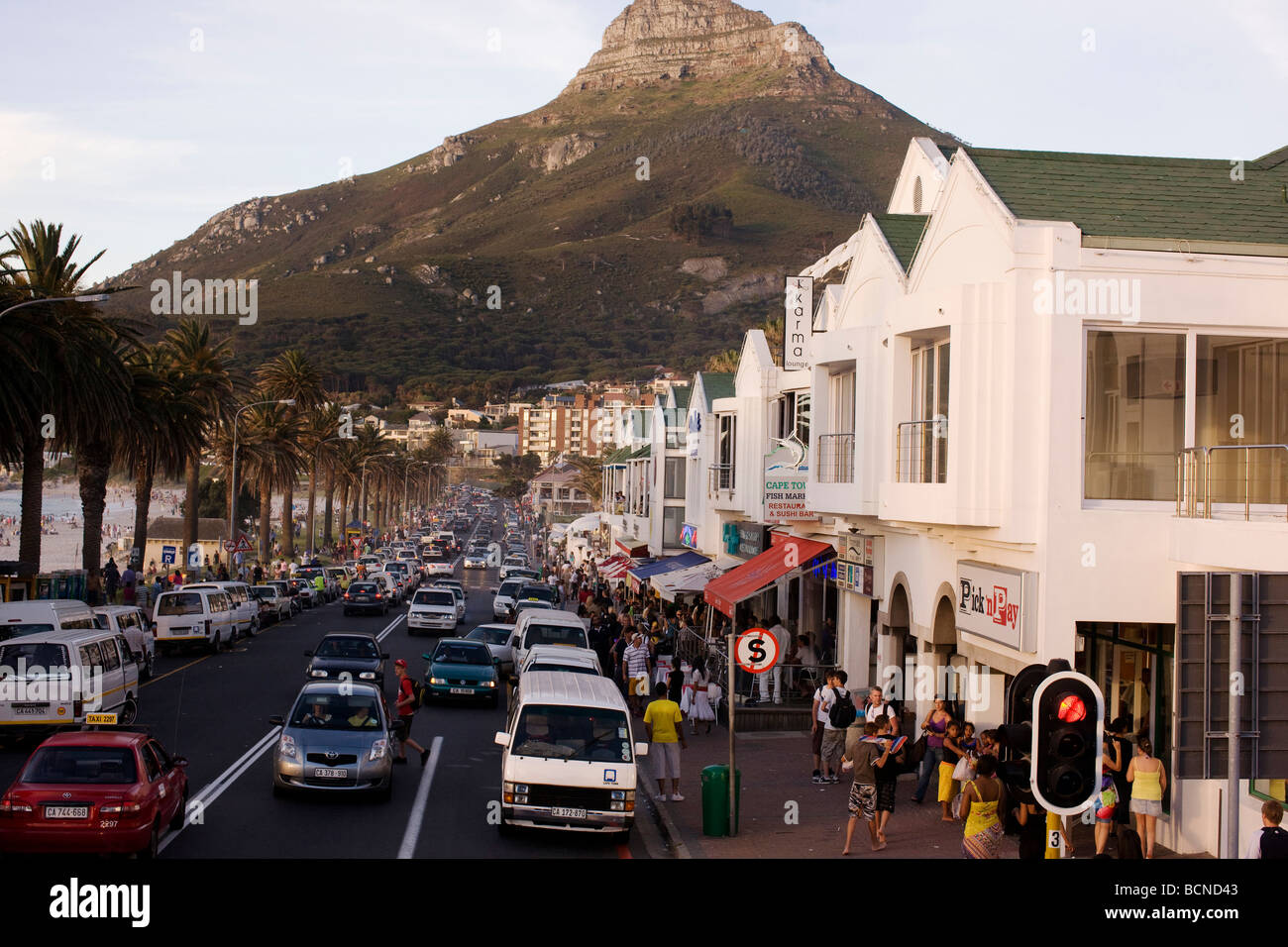 Scena di strada a Camps Bay a Cape Town con Lionshead in background Foto Stock