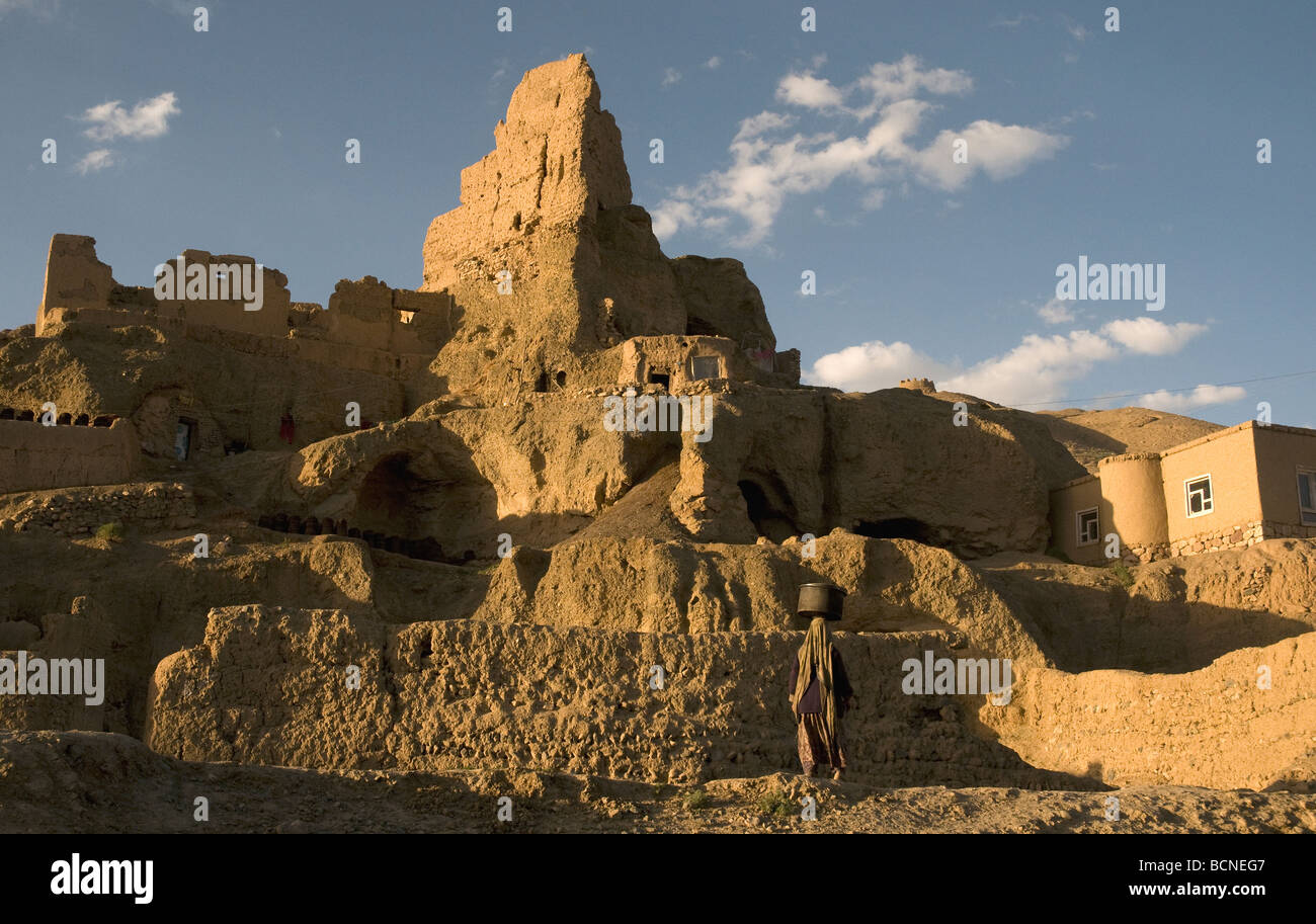 Ad ovest delle grandi nicchie di Buddha di Bamiyan di scogliere di arenaria, Afghanistan, balze aggettante fornire case per le famiglie e i rifugiati Foto Stock