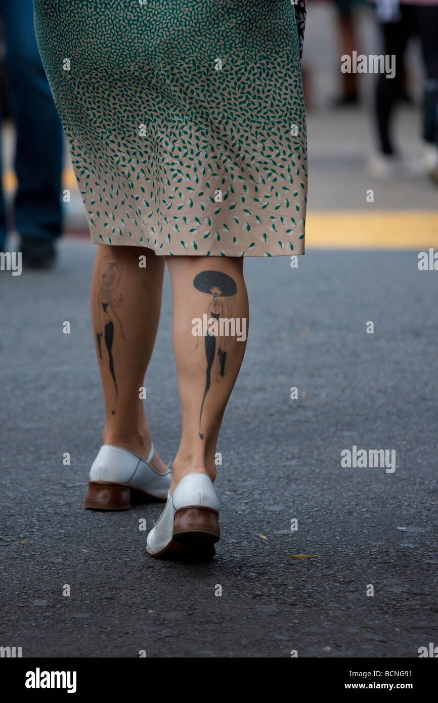 Una donna che cammina nel Haight Ashbury e distretto con due tatuaggi e il suo croste, Haight Street, San Francisco, California, Stati Uniti d'America Foto Stock