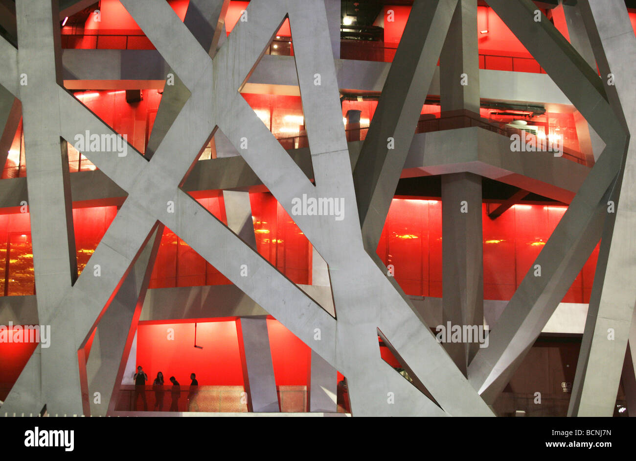 Massicce travi in acciaio e illuminazione drammatica all'interno del Bird's Nest, Pechino, Cina Foto Stock