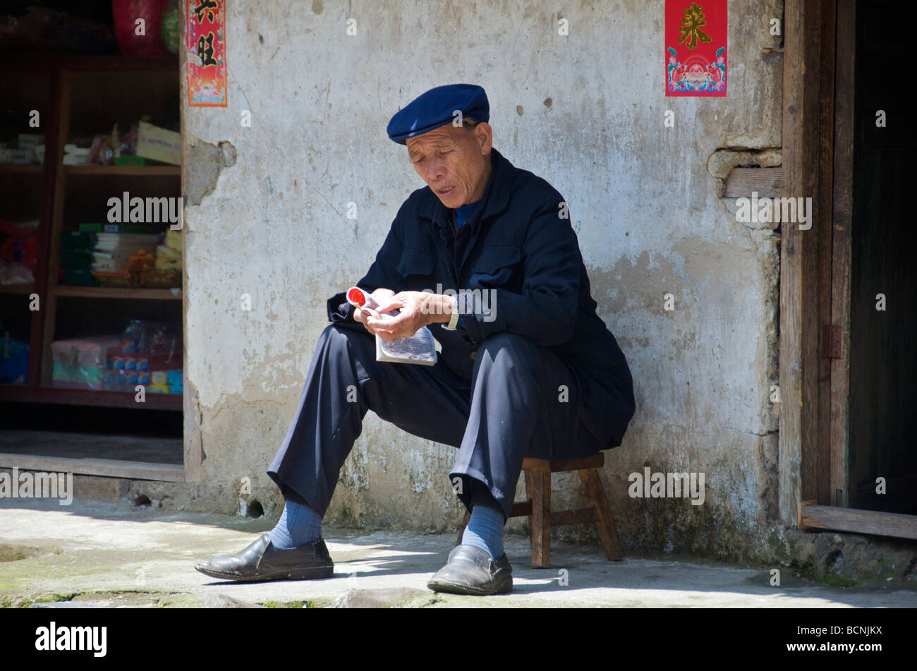 Yao uomo lettura tribù di minoranza villaggio cinese di Guangxi Foto Stock