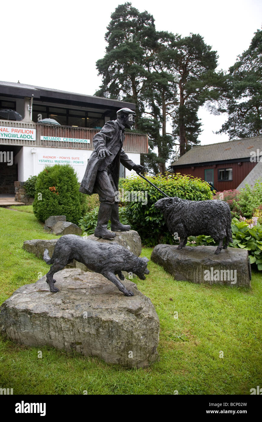 La scultura di un pastore gallese, il suo sheepdog e una pecora a visitatori internazionali del Padiglione del Royal Welsh showground. Foto Stock