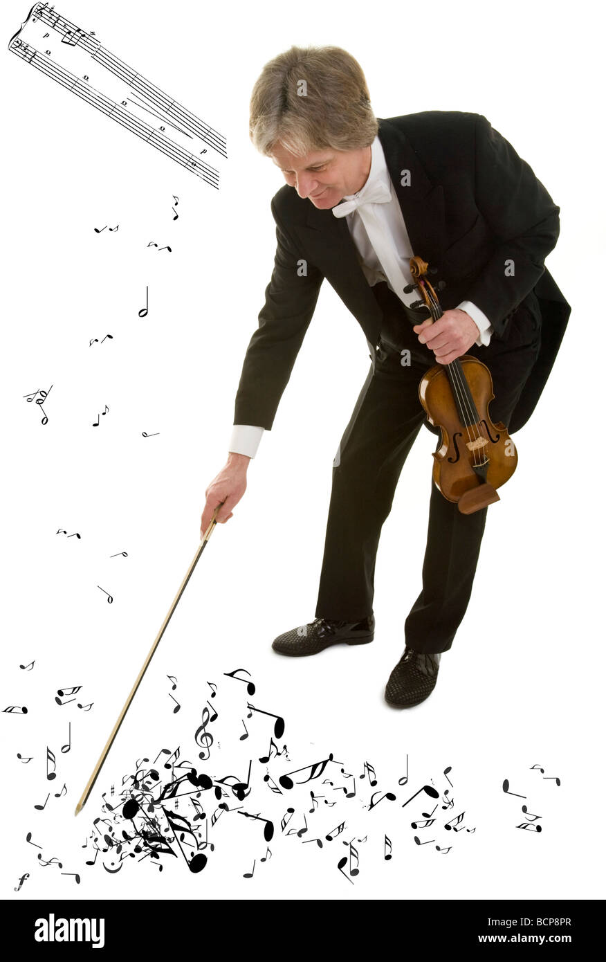Il violinista im Frack fegt mit seinem Bogen Musiknoten auf dem Boden zusammen Foto Stock