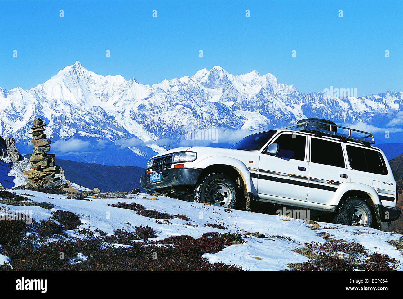 Un veicolo da neve Baimang montagna con lo sfondo del Kawa Dampa picco di Meili Snow Mountain, Shangri-la, DiQing Foto Stock