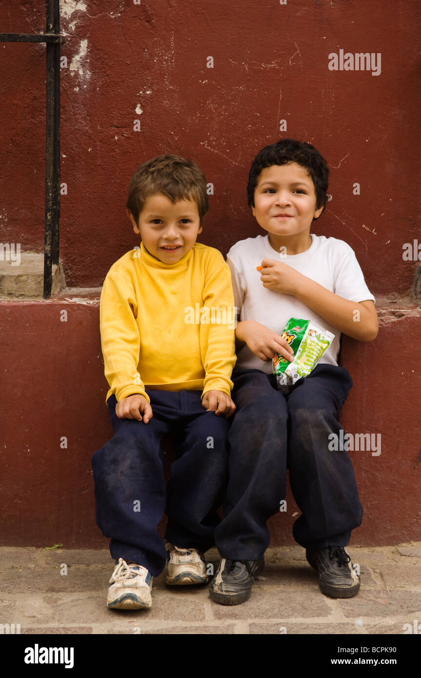 Due ragazzi con snack seduti sul cordolo Cosala Sinaloa Messico Foto Stock