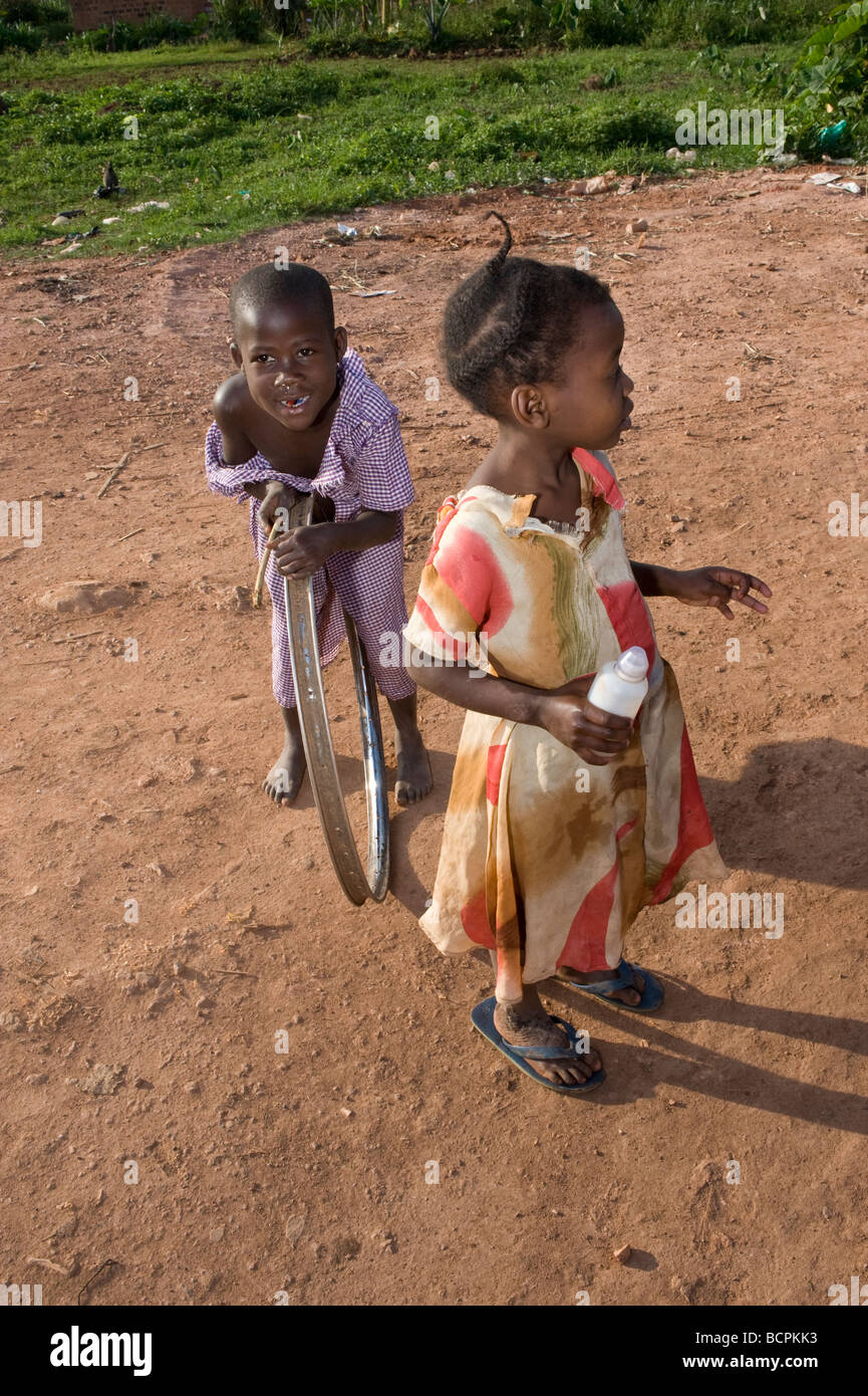 Due bambini su terra rossa street nella baraccopoli di Kampala Foto Stock