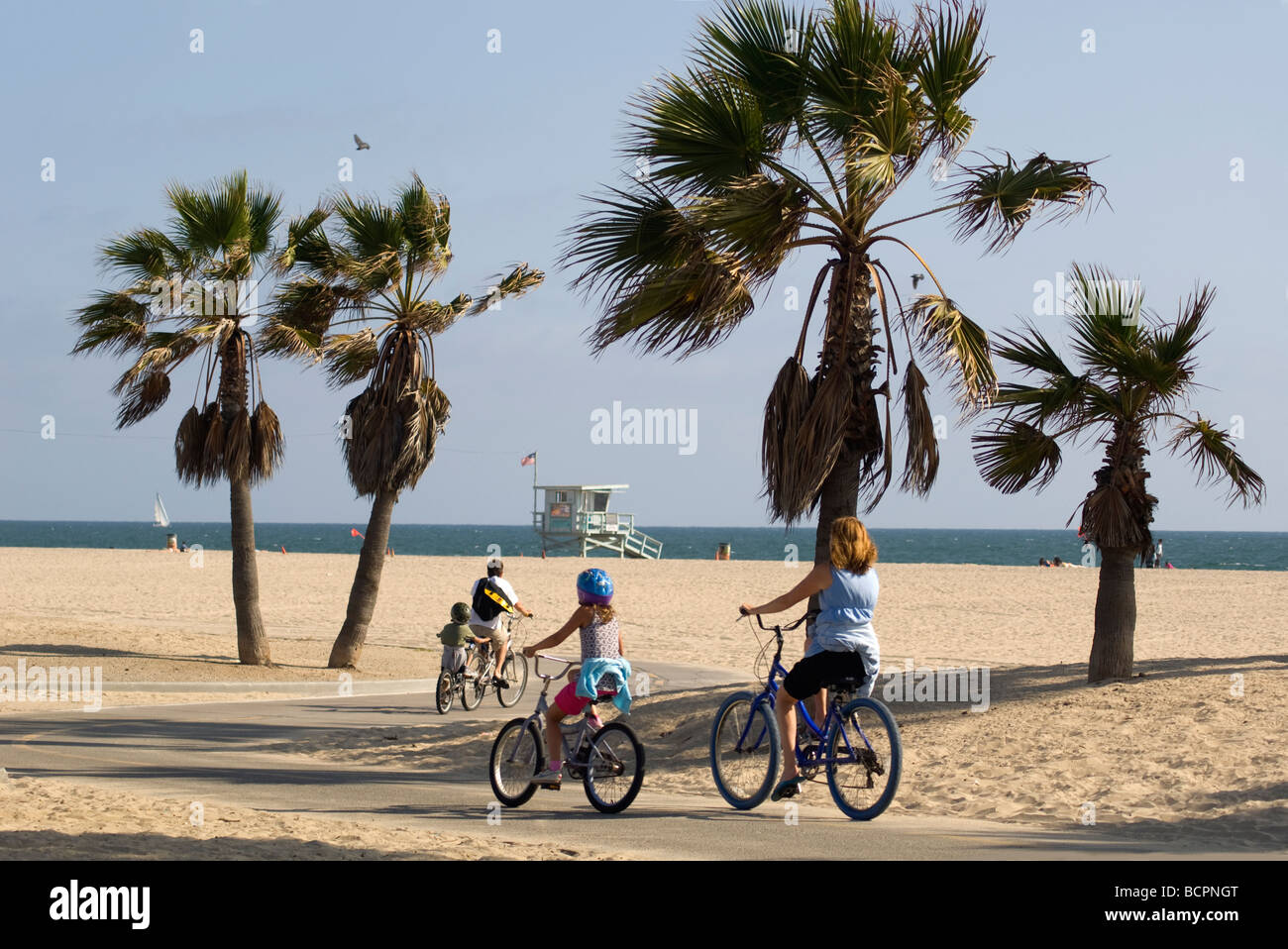 Una visita con la famiglia alla spiaggia di Los Angeles include un giro in bicicletta sulla pista ciclabile fronte oceano. Foto Stock