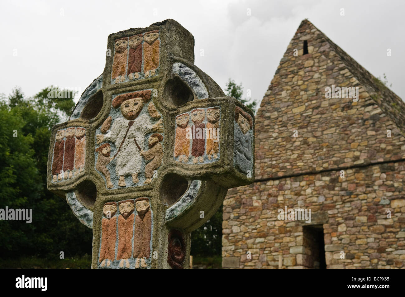 Ornati dipinti croce celtica con un depictino di San Patrizio nel centro,a un villaggio monastico nella Irish National Heritage Park, nella contea di Wexford. Foto Stock