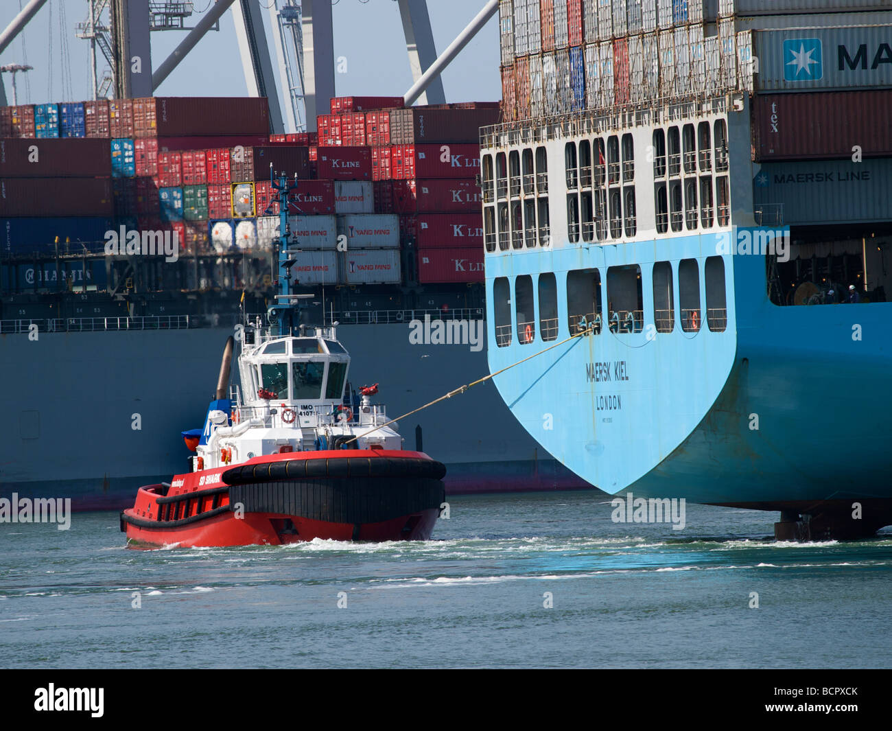 Rimorchiatore tirando una grande nave container nel porto di Rotterdam Zuid Holland Olanda Foto Stock