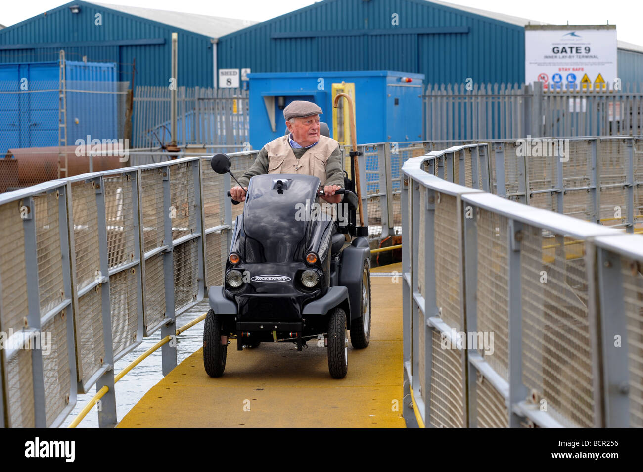 Un vecchio uomo su una mobilità scooter attraversa il ponte di bloccaggio a Shoreham Foto Stock