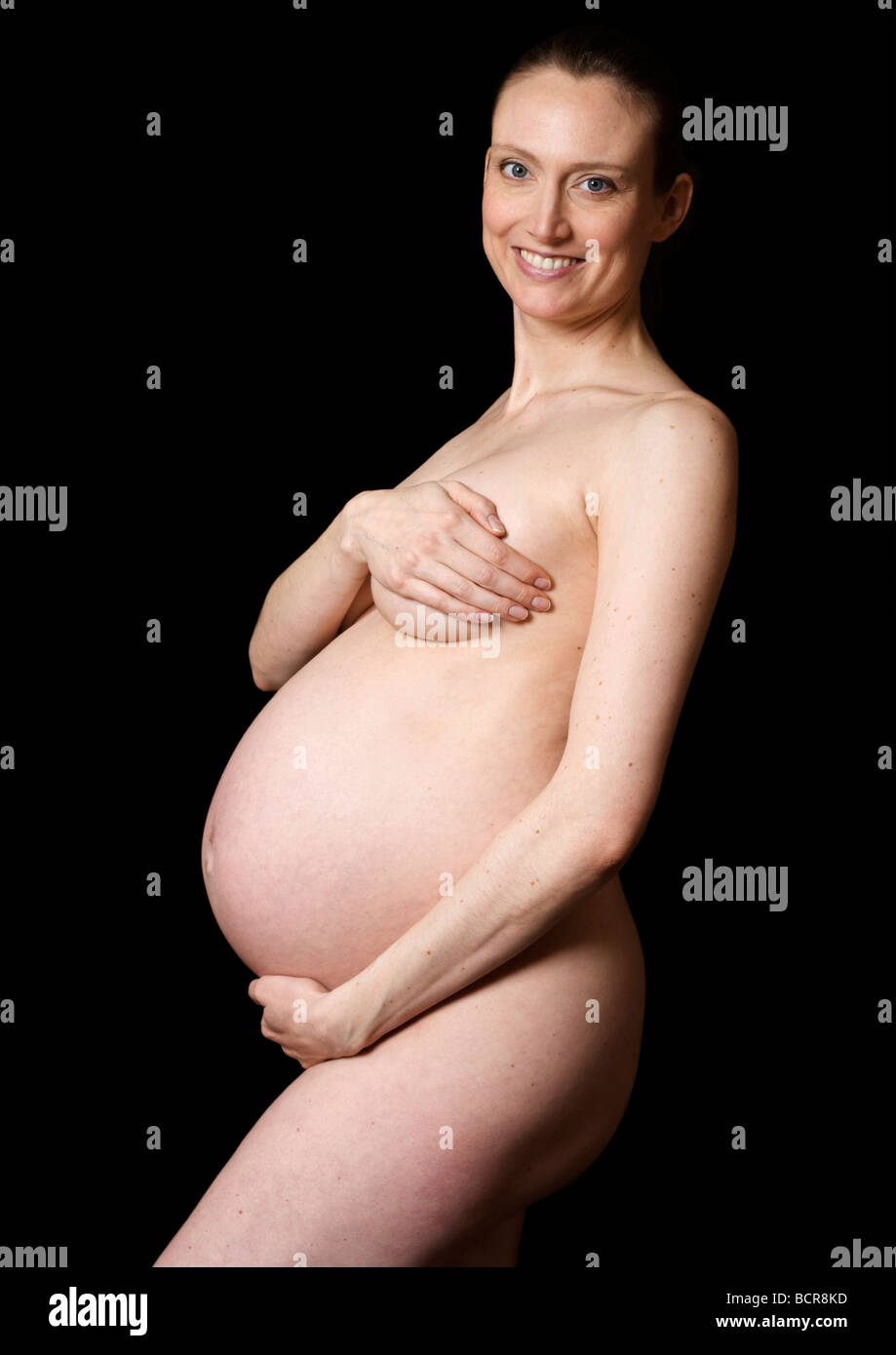 Nudo di donna incinta a 38 settimane che copre il seno Foto stock