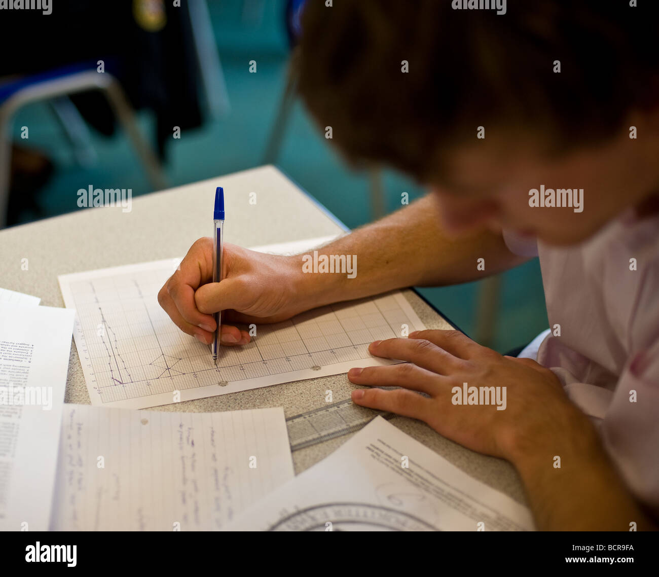 Un giovane studente maschio lavorando su un grafico Foto Stock